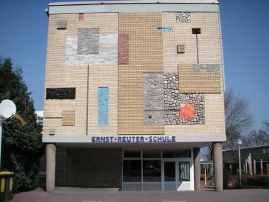 Ernst-Reuter-Schule Fassade eines mehrstöckigen Schulgebäudes mit verschiedenen rechteckigen Mauerwerksmustern und dem Schriftzug 'ERNST-REUTER-SCHULE'