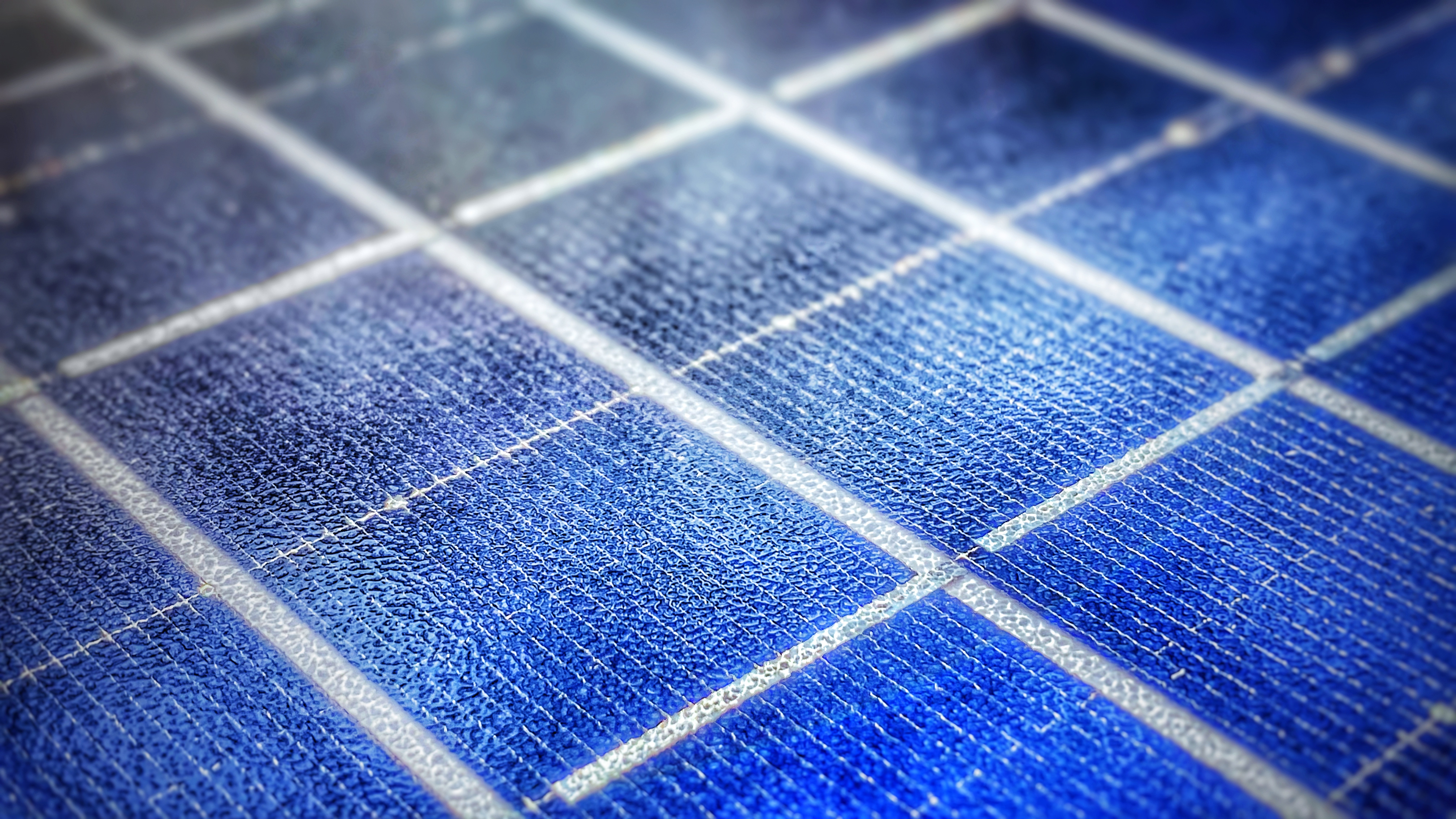 Nahaufnahme einer blauen Solarzelle mit weißen Trennlinien