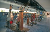 Museumsausstellung mit historischen Destillationsapparaten aus Kupfer und Metall in einer modernen, hellen Halle
