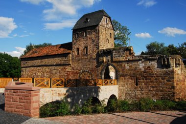 Historische Wasserburg mit Tor und Zinnen unter blauem Himmel