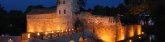 Beleuchtete mittelalterliche Wasserburg mit Brücke und Wassergraben bei Nacht