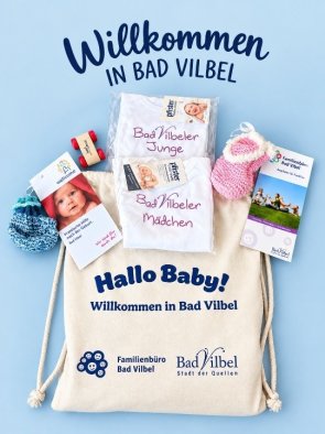 Turnbeutel mit der Aufschrift 'Hallo Baby! Willkommen in Bad Vilbel' und Logos von Familienbüro Bad Vilbel und Stadt Bad Vilbel, umgeben von Babybodys mit den Aufschriften 'Bad Vilbeler Junge' und 'Bad Vilbeler Mädchen', zwei Paar Babysocken und Informationsbroschüren.