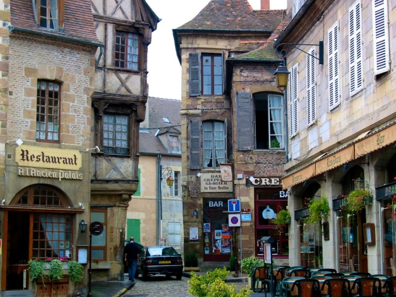 Enge Gasse in Moulins mit Fachwerkhäusern, Restaurants und Außensitzplätzen in einer französischen Altstadt