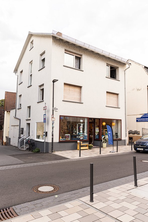 Dreistöckiges Wohn- und Geschäftshaus mit großen Schaufenstern im Erdgeschoss