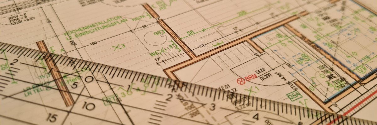 Nahaufnahme eines Bebauungsplans mit Lineal und verschiedenen farbigen Markierungen und Linien