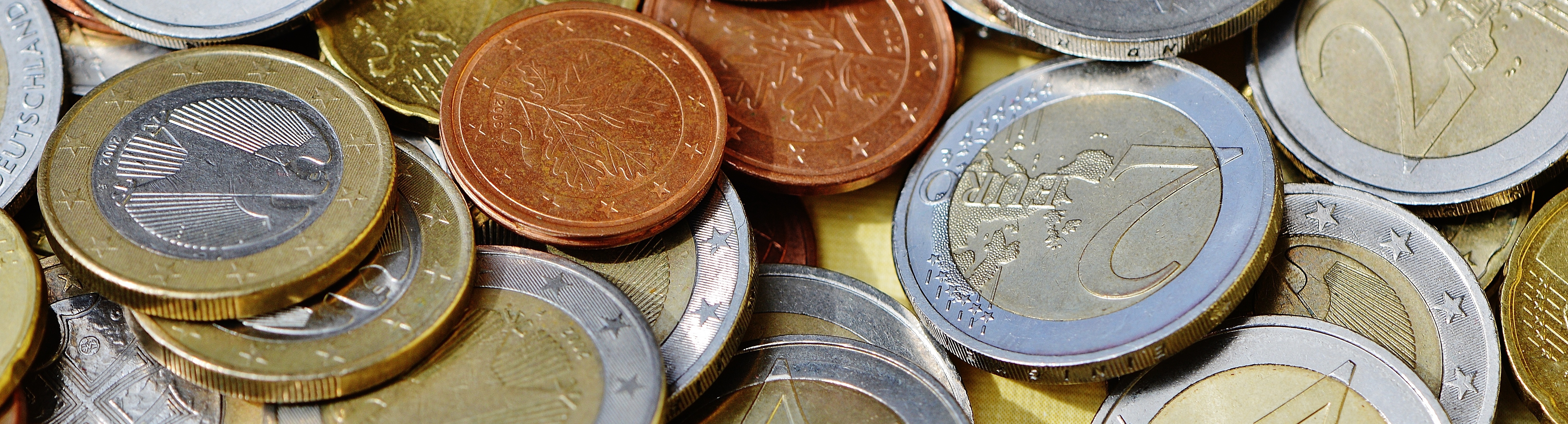 Nahaufnahme von mehreren Euro-Münzen unterschiedlicher Stückelung und Farbe
